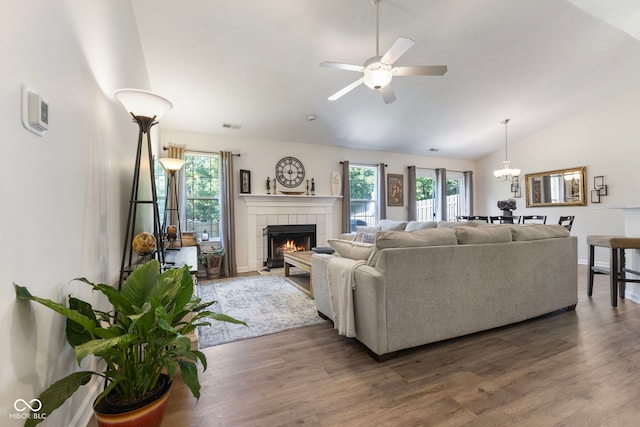 7009 Thousand Oaks Ln, Indianapolis, IN 46214 - living room with vaulted ceiling, plenty of natural light, a tiled fireplace, ceiling fan, and a chandelier