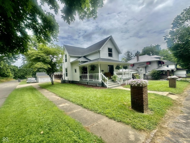 513 N Main St, Veedersburg, IN 47987 - view of front facade featuring a porch, a front yard, and a detached garage