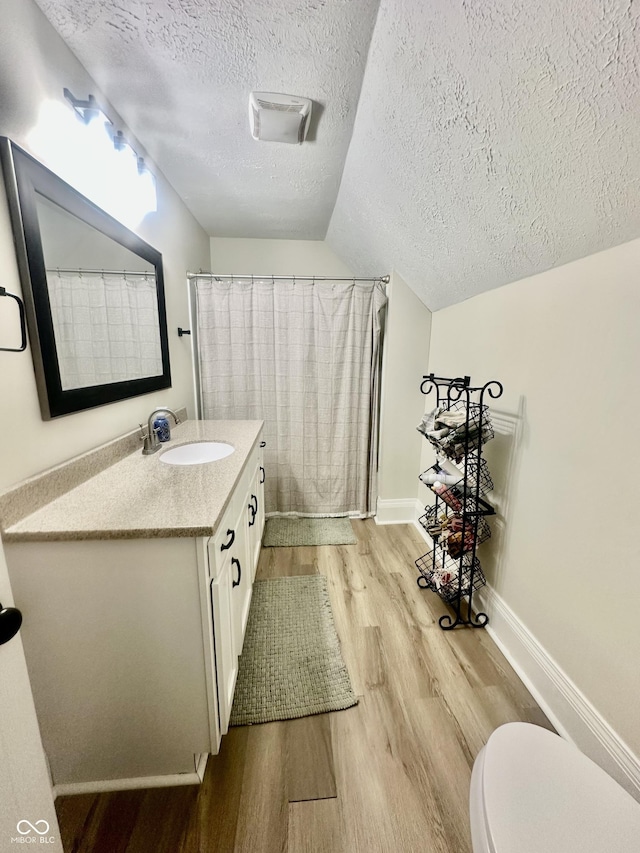 513 N Main St, Veedersburg, IN 47987 - full bath with wood finished floors, vanity, a textured ceiling, lofted ceiling, and curtained shower