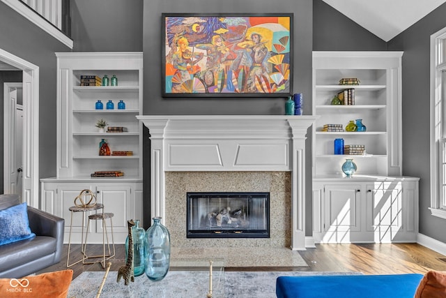 11354 Redwing Ct, Fishers, IN 46037 - living area featuring a fireplace, wood finished floors, built in shelves, and vaulted ceiling