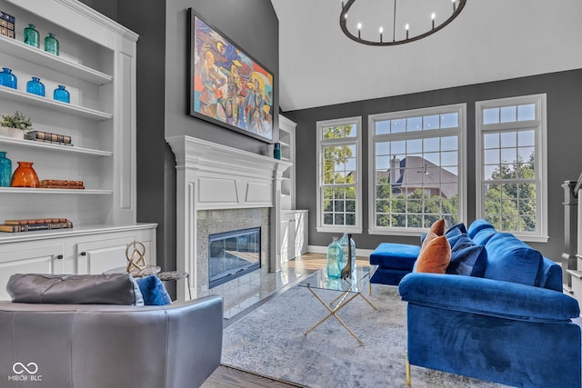11354 Redwing Ct, Fishers, IN 46037 - living room featuring a chandelier, a fireplace, wood finished floors, built in shelves, and lofted ceiling