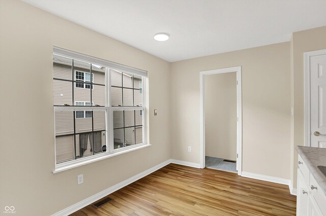 3084 Armory Dr, Indianapolis, IN 46208 - unfurnished dining area with baseboards and light wood finished floors