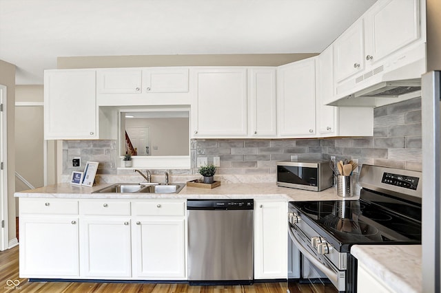 3084 Armory Dr, Indianapolis, IN 46208 - kitchen with appliances with stainless steel finishes, under cabinet range hood, white cabinets, and backsplash