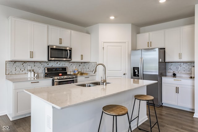 6143 Madera Dr, Whitestown, IN 46075 - kitchen with appliances with stainless steel finishes, dark wood-style flooring, backsplash, white cabinets, and recessed lighting