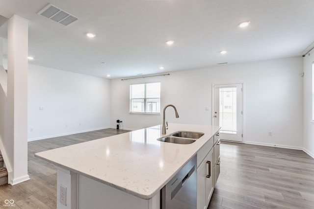 6143 Madera Dr, Whitestown, IN 46075 - kitchen featuring stainless steel dishwasher, light wood-style flooring, recessed lighting, an island with sink, and light stone counters