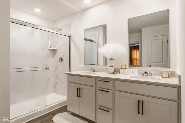 6143 Madera Dr, Whitestown, IN 46075 - full bathroom featuring double vanity, a marble finish shower, wood finished floors, and recessed lighting