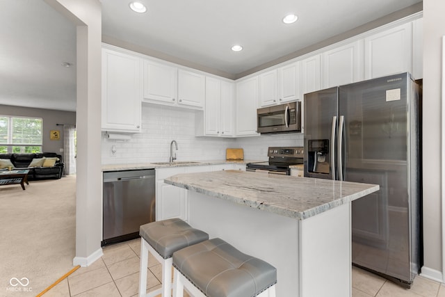 866 Rosalind Pl, Carmel, IN 46032 - kitchen with appliances with stainless steel finishes, white cabinetry, light tile patterned flooring, light stone countertops, and recessed lighting