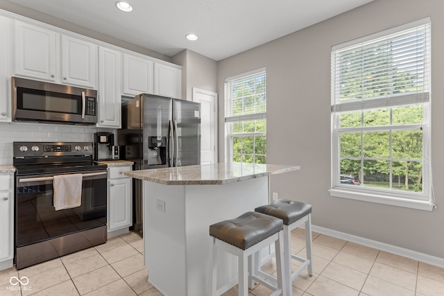 866 Rosalind Pl, Carmel, IN 46032 - kitchen with appliances with stainless steel finishes, light tile patterned flooring, tasteful backsplash, white cabinetry, and recessed lighting