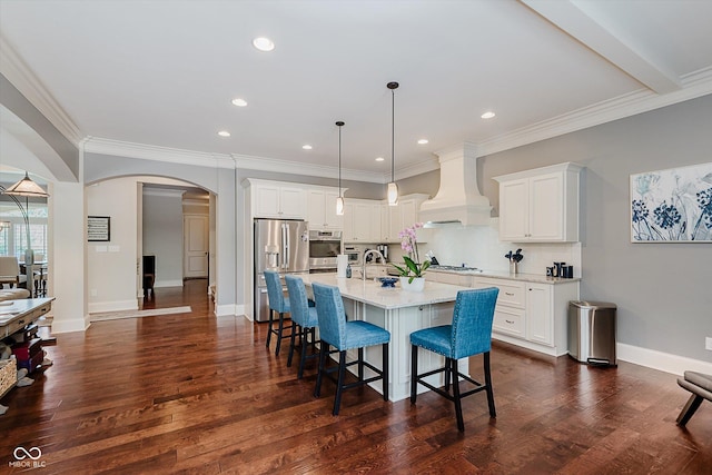 4545 Pascagoula Run, Greenwood, IN 46143 - kitchen featuring custom range hood, stainless steel appliances, arched walkways, a breakfast bar area, and dark wood finished floors