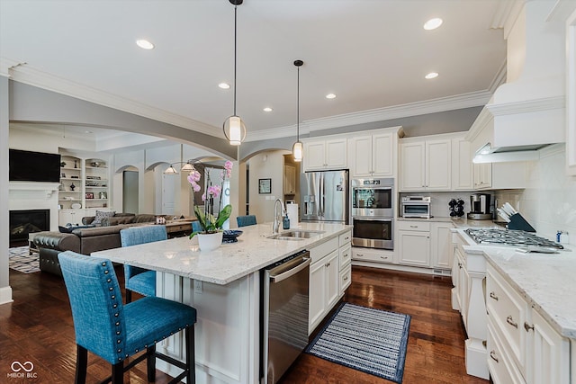 4545 Pascagoula Run, Greenwood, IN 46143 - kitchen featuring stainless steel appliances, arched walkways, ornamental molding, custom exhaust hood, and light stone counters