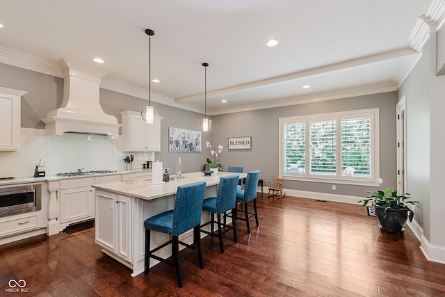 4545 Pascagoula Run, Greenwood, IN 46143 - kitchen featuring custom exhaust hood, an island with sink, a kitchen bar, tasteful backsplash, and dark wood-type flooring
