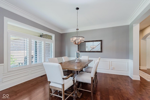 4545 Pascagoula Run, Greenwood, IN 46143 - dining area featuring a chandelier, ornamental molding, arched walkways, dark wood-type flooring, and wainscoting