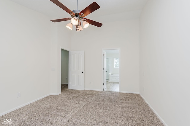 12291 Cobblestone Dr, Fishers, IN 46037 - empty room featuring carpet floors, a ceiling fan, and a high ceiling