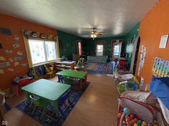 3209 Forest Ter, Anderson, IN 46013 - living area with arched walkways, wood finished floors, and a ceiling fan