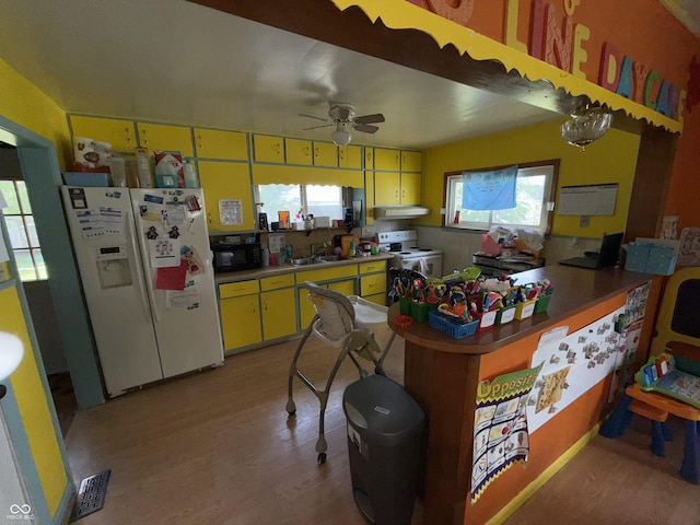 3209 Forest Ter, Anderson, IN 46013 - kitchen with white appliances, wood finished floors, a ceiling fan, under cabinet range hood, and a peninsula