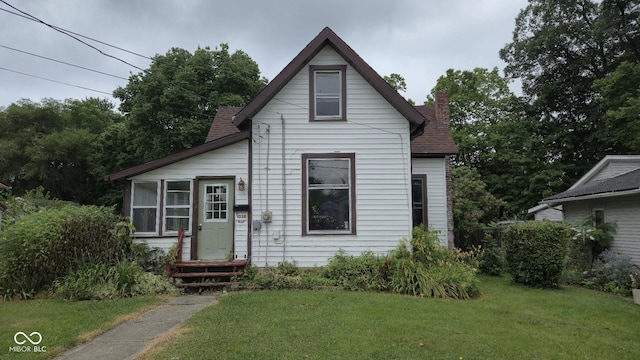 1338 Glenn Ave, Wabash, IN 46992 - view of front of house featuring a chimney, a front lawn, and a shingled roof