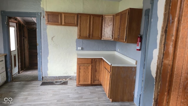 1338 Glenn Ave, Wabash, IN 46992 - kitchen featuring brown cabinets, light countertops, light wood finished floors, and a textured wall