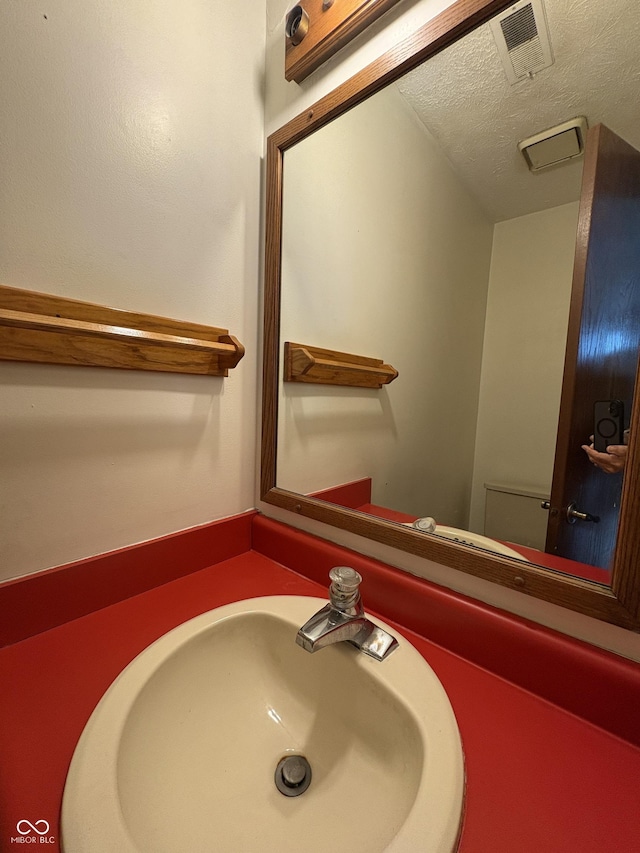 6458 Watham Ct, Indianapolis, IN 46250 - half bath featuring a sink and a textured ceiling