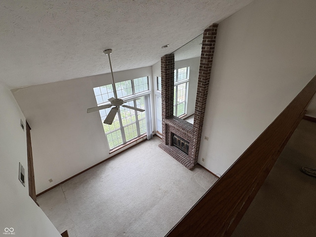 6458 Watham Ct, Indianapolis, IN 46250 - unfurnished living room featuring light carpet, a textured ceiling, ceiling fan, a fireplace, and lofted ceiling