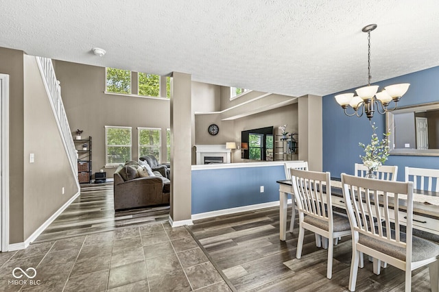 12034 Gatwick View Dr, Fishers, IN 46037 - dining space featuring a textured ceiling, a chandelier, and a fireplace