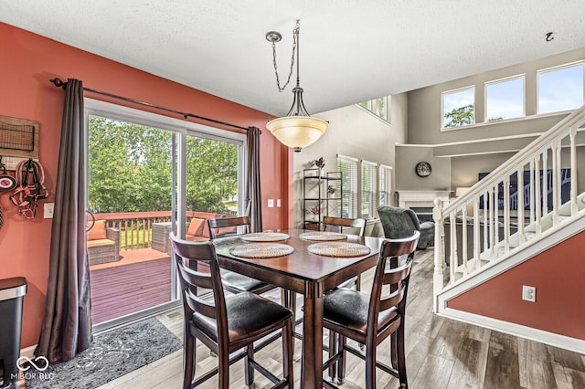 12034 Gatwick View Dr, Fishers, IN 46037 - dining room with wood finished floors, a textured ceiling, and stairway