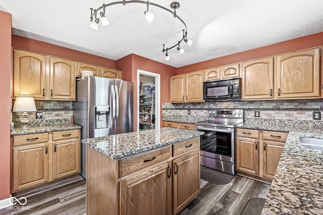 12034 Gatwick View Dr, Fishers, IN 46037 - kitchen featuring stainless steel appliances, dark wood-type flooring, light stone counters, backsplash, and a kitchen island