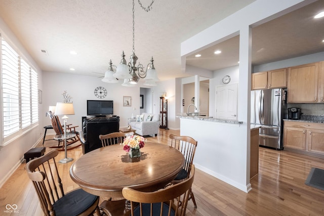 12985 Merlot Ln, Fishers, IN 46037 - dining room featuring light wood-style flooring, a chandelier, recessed lighting, and a textured ceiling