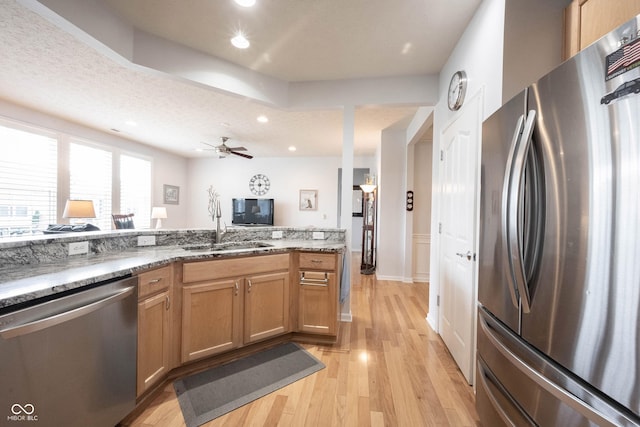 12985 Merlot Ln, Fishers, IN 46037 - kitchen with stainless steel appliances, light wood finished floors, light stone countertops, a ceiling fan, and recessed lighting