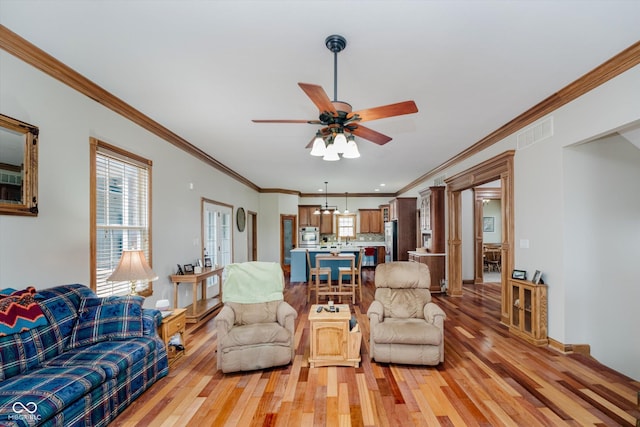 7178 Lockford Walk N, Avon, IN 46123 - living area featuring light wood-style floors, ceiling fan, and ornamental molding