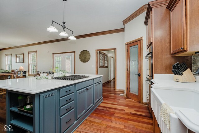 7178 Lockford Walk N, Avon, IN 46123 - kitchen with crown molding, stainless steel gas stovetop, light countertops, light wood finished floors, and open shelves
