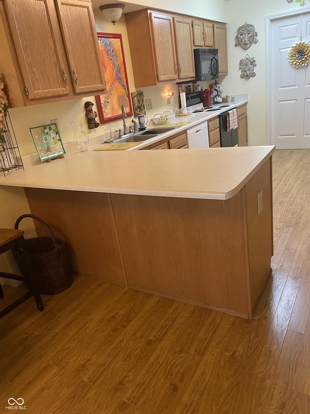 5333 Thornridge Pl, Indianapolis, IN 46237 - kitchen with white appliances, light countertops, light wood-style flooring, and a peninsula