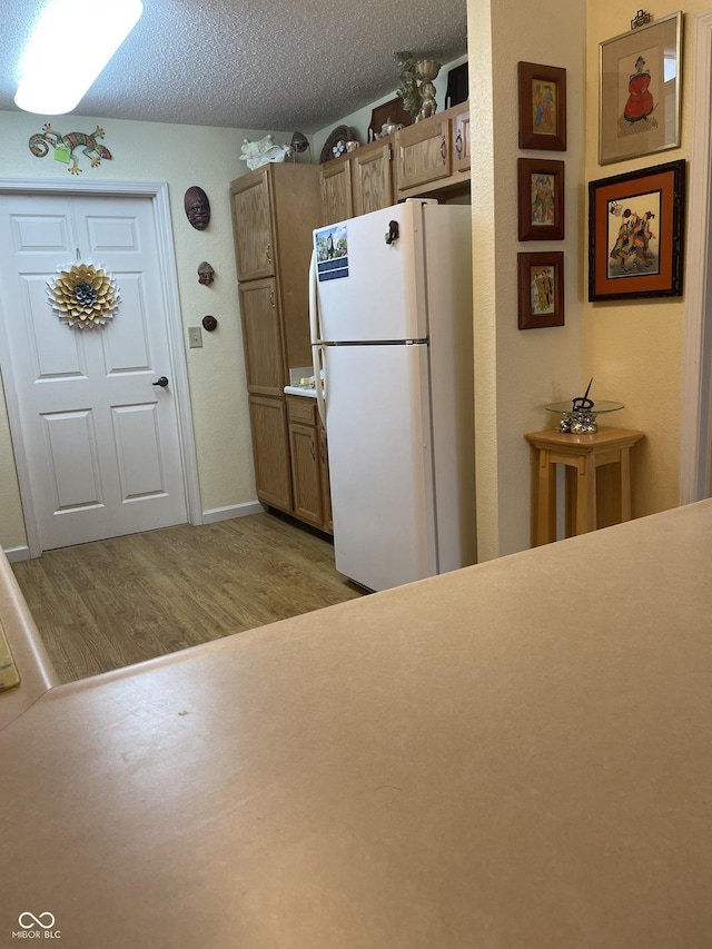 5333 Thornridge Pl, Indianapolis, IN 46237 - kitchen featuring freestanding refrigerator, light wood-style flooring, a textured ceiling, and brown cabinets