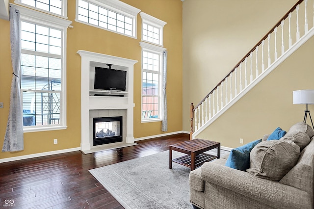4219 Trilithon Ct, West Lafayette, IN 47906 - living area with dark wood finished floors, a tiled fireplace, a towering ceiling, and stairs