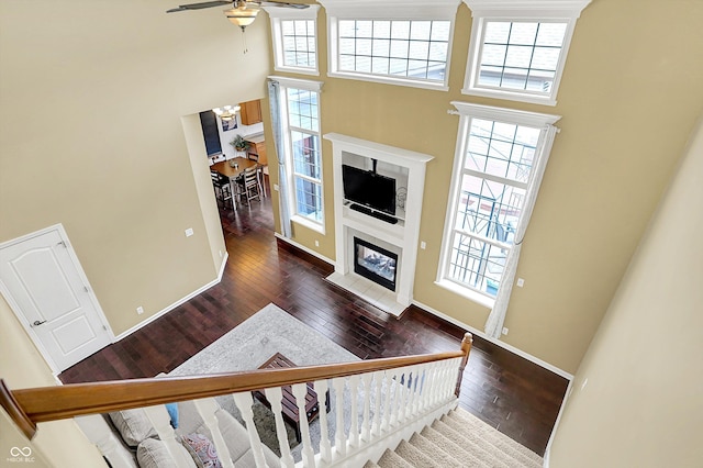 4219 Trilithon Ct, West Lafayette, IN 47906 - stairs with a high ceiling, hardwood / wood-style flooring, a ceiling fan, a fireplace with flush hearth, and a chandelier