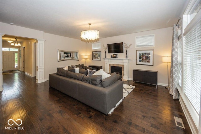 15540 Provincial Ln, Fishers, IN 46040 - living room featuring a chandelier, ornate columns, dark wood-style flooring, and a tile fireplace