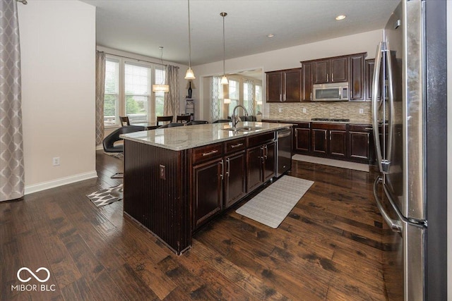 15540 Provincial Ln, Fishers, IN 46040 - kitchen with stainless steel appliances, dark wood finished floors, tasteful backsplash, a kitchen bar, and light stone countertops