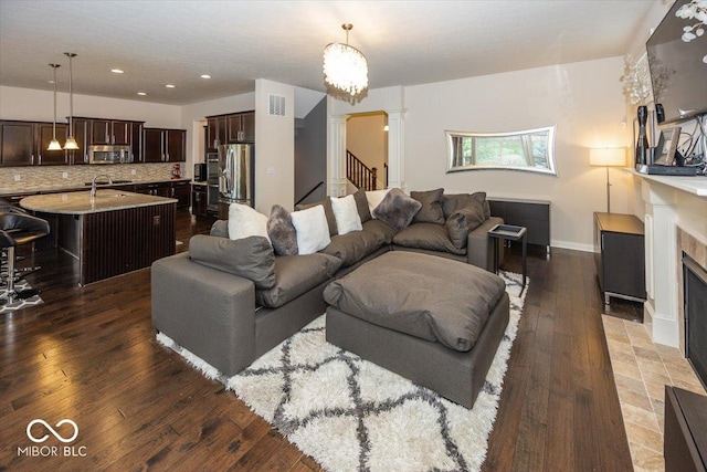 15540 Provincial Ln, Fishers, IN 46040 - living room with ornate columns, hardwood / wood-style flooring, stairway, a tile fireplace, and recessed lighting