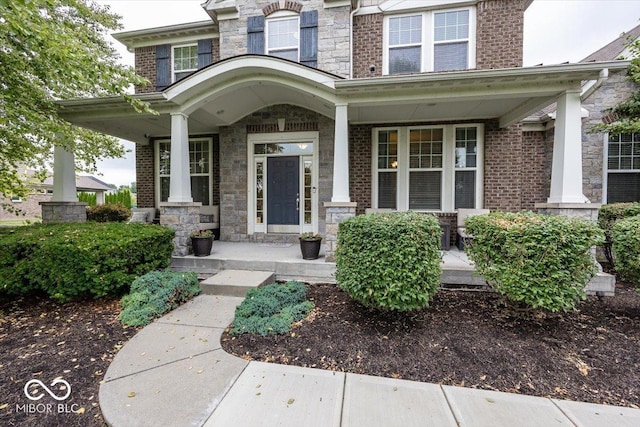 15540 Provincial Ln, Fishers, IN 46040 - property entrance featuring covered porch, stone siding, and brick siding