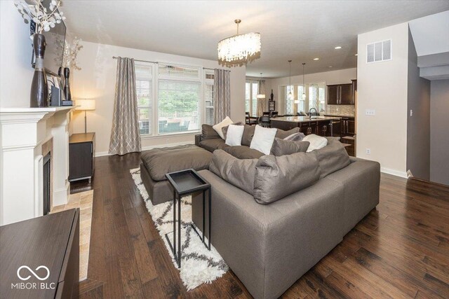 15540 Provincial Ln, Fishers, IN 46040 - living room with dark wood-type flooring, a chandelier, recessed lighting, and a fireplace with flush hearth