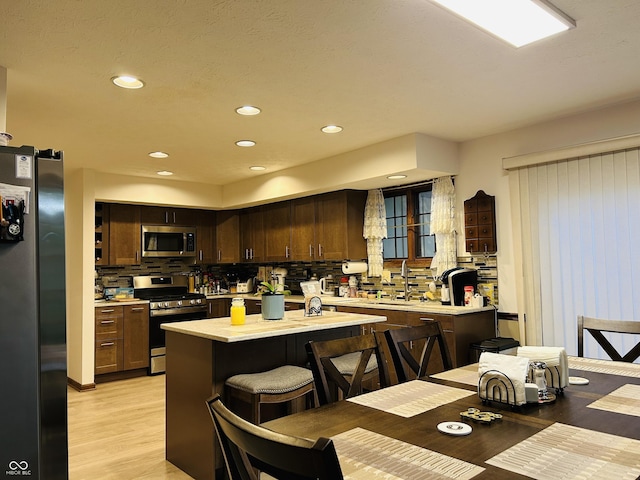 8413 Catamaran Dr, Indianapolis, IN 46236 - kitchen featuring appliances with stainless steel finishes, light countertops, backsplash, light wood-type flooring, and recessed lighting
