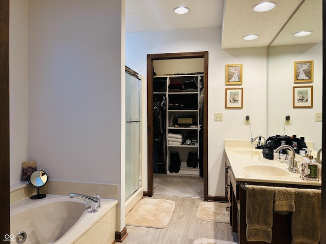 8413 Catamaran Dr, Indianapolis, IN 46236 - full bath featuring a garden tub, a stall shower, a walk in closet, double vanity, and wood finished floors
