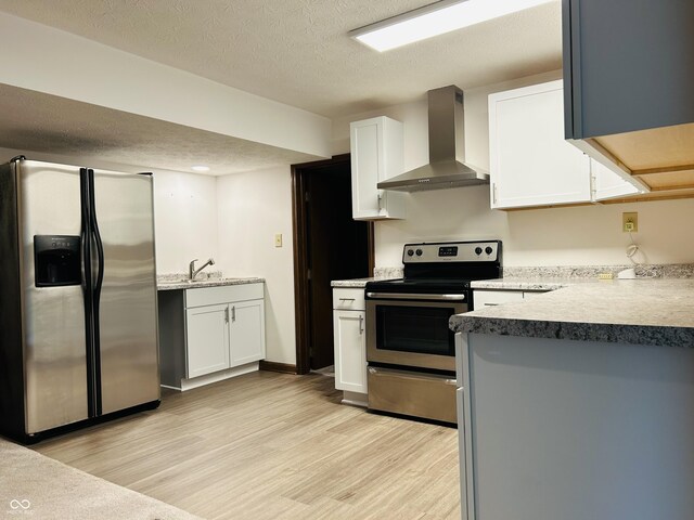8413 Catamaran Dr, Indianapolis, IN 46236 - kitchen with stainless steel appliances, wall chimney range hood, light wood-style flooring, white cabinetry, and a textured ceiling