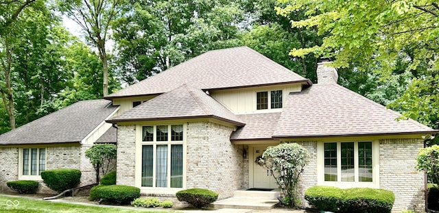 8413 Catamaran Dr, Indianapolis, IN 46236 - view of front of home with a chimney, brick siding, roof with shingles, and board and batten siding
