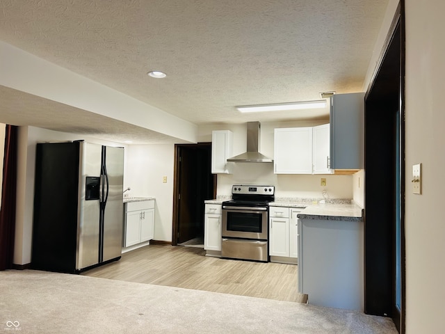 8413 Catamaran Dr, Indianapolis, IN 46236 - kitchen with appliances with stainless steel finishes, wall chimney exhaust hood, a textured ceiling, white cabinets, and light wood-style floors