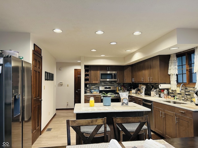 8413 Catamaran Dr, Indianapolis, IN 46236 - kitchen featuring stainless steel appliances, light wood-style floors, backsplash, dark brown cabinetry, and recessed lighting