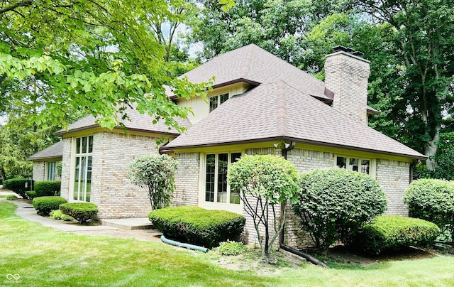 8413 Catamaran Dr, Indianapolis, IN 46236 - view of property exterior with a chimney, a lawn, brick siding, and roof with shingles