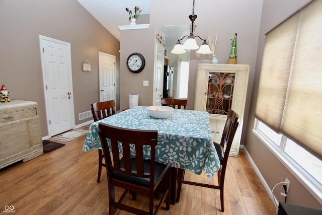 2909 Inverrary Ct, Indianapolis, IN 46234 - dining room with light wood-style floors, lofted ceiling, and a chandelier