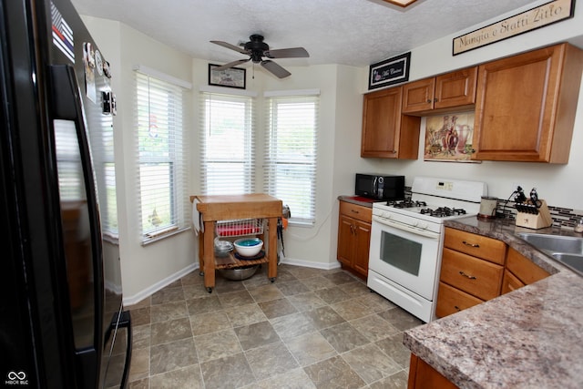 2909 Inverrary Ct, Indianapolis, IN 46234 - kitchen featuring black appliances, brown cabinetry, plenty of natural light, a ceiling fan, and a textured ceiling