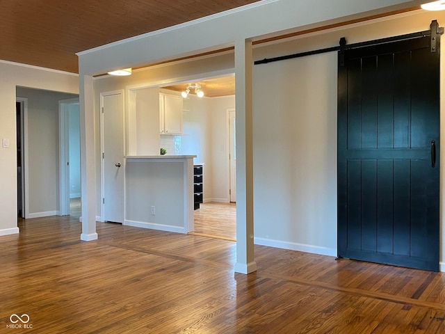 945 E Worthsville Rd, Greenwood, IN 46143 - unfurnished living room featuring a barn door, ornamental molding, and hardwood / wood-style floors