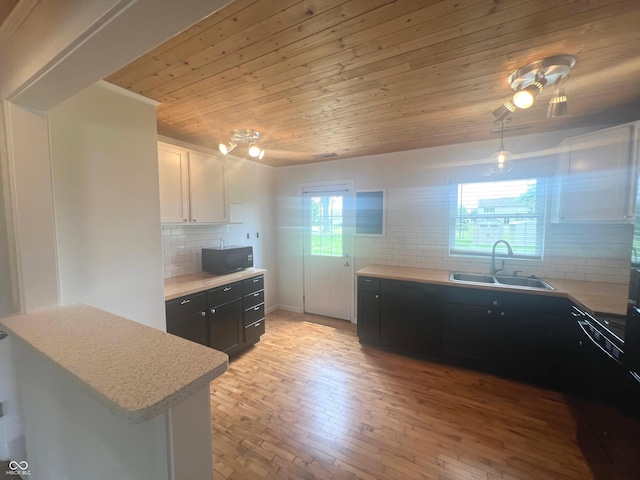 945 E Worthsville Rd, Greenwood, IN 46143 - kitchen with black microwave, decorative backsplash, wood ceiling, light countertops, and dark cabinetry